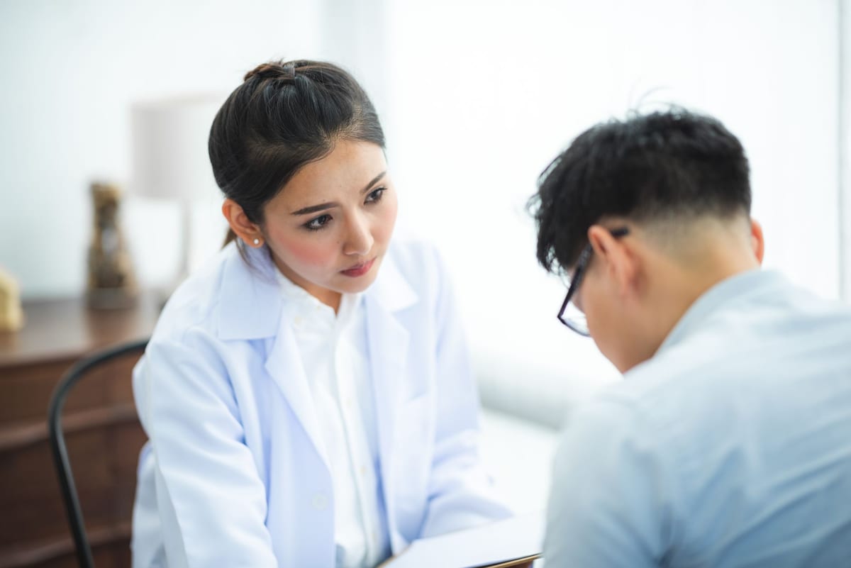 A doctor listening closely to a patient during an appointment