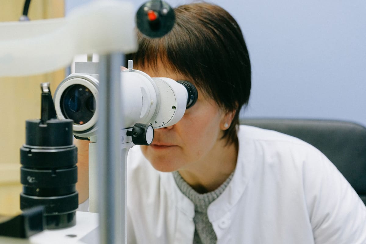 An eye doctor looking through a slit lamp